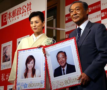 記者会見でフレーム切手の拡大見本を手にする女優の米倉涼子さん(左)と日本郵政公社の生田正治総裁(右)=東京都港区虎ノ門のホテルオークラ東京(撮影・大井田裕)