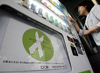 飲料の売り上げの一部が募金にあてられることを告知するポスターが掲示された自販機=東京都新宿区