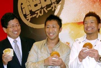 「絶品チーズバーガー」をPRするWBC世界フライ級チャンピオンの内藤大助選手(中央)ら=29日、東京・池袋のロッテリア池袋東口店