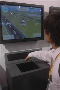 アルプス電気が出展したテレビゲームは、手のひらの傾きをセンサーが感知し、画面上のヘリコプターを操作する