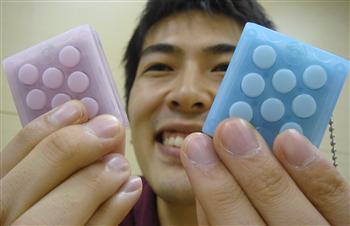 「∞プチプチ」を手にするバンダイの高橋晋平さん。突起を押すと、内蔵スピーカーから気泡シートの破裂音が出る