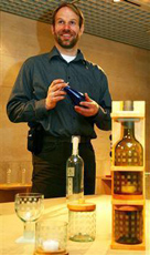 使用済みのガラス瓶で作品を制作するユッカ・イソタロさん。ワインボトル（右）を３分割するとグラス、キャンドルホルダー、シュガーケース（左から）に