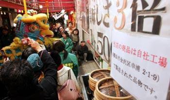 「春節」の獅子舞巡行で沸く横浜中華街。店頭には「自社工場で生産しました」の張り紙も=7日午後、横浜市