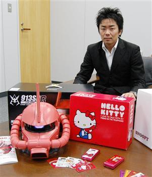 「機動戦士ガンダム」などのキャラケー。右はガンダム携帯の企画に携わった吉田真佑氏