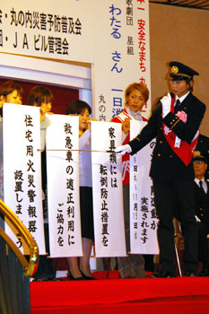 “湖月署長”による標語の解説も。垂れ幕をひとつひとつ読み上げ、会場のファンに認識を促した